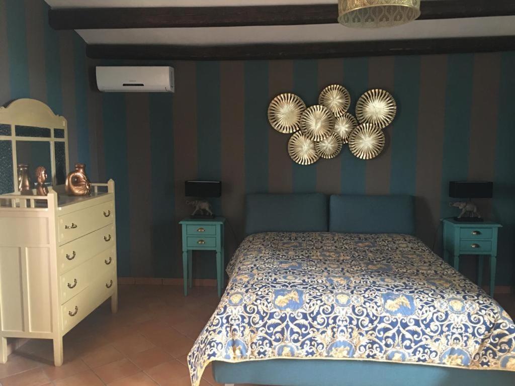 sypialnia z łóżkiem, komodą i dwoma stołami w obiekcie La stanza delle Muse in Villa con Piscina w mieście Fontane Bianche