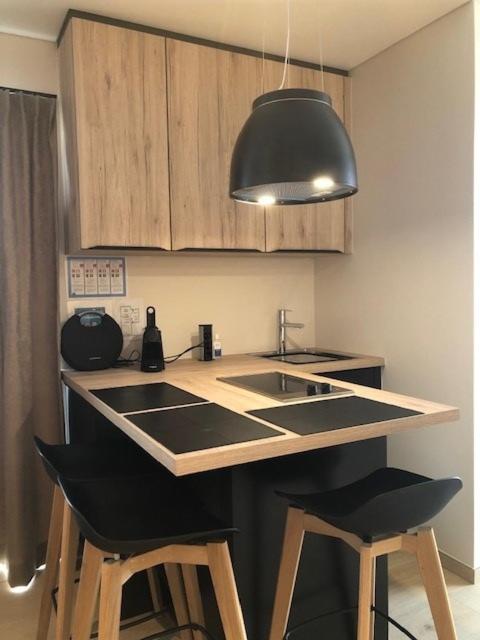 a kitchen with a sink and two bar stools at Vakantiehuis Onverbloemd in Tielt