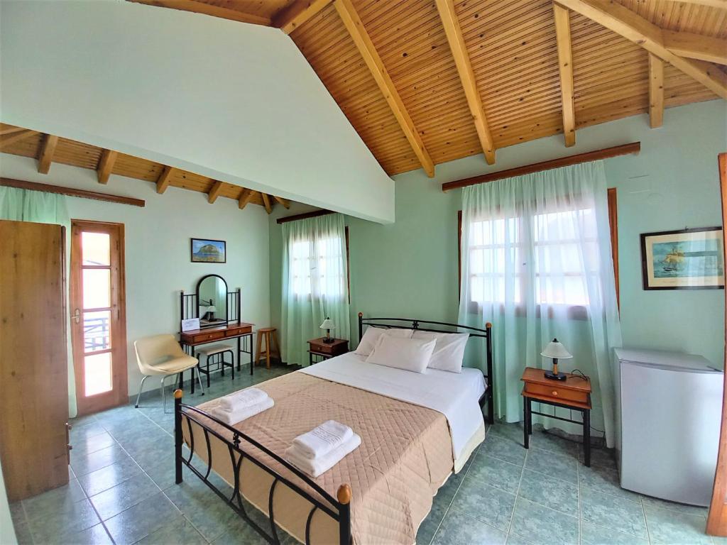 a bedroom with a bed and a desk and windows at AGNANTIO in Monemvasia