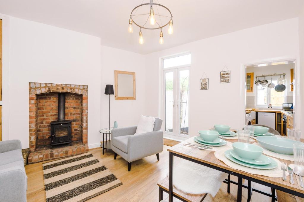 a living room with a table and a fireplace at Churton House in Chester