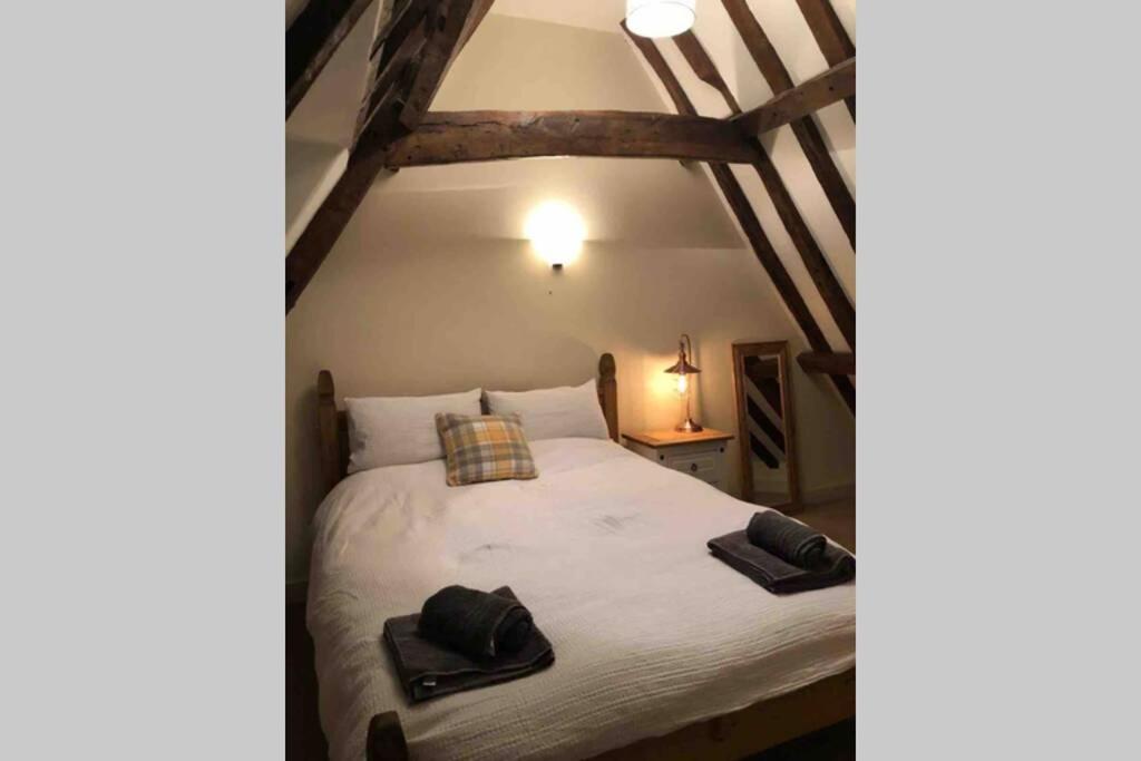 a bedroom with a bed with two towels on it at Quirky 3 bedroom property in Wymondham