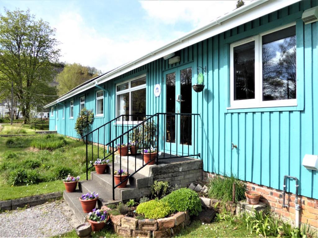 una casa blu con delle piante davanti di Inveraray Hostel a Inveraray