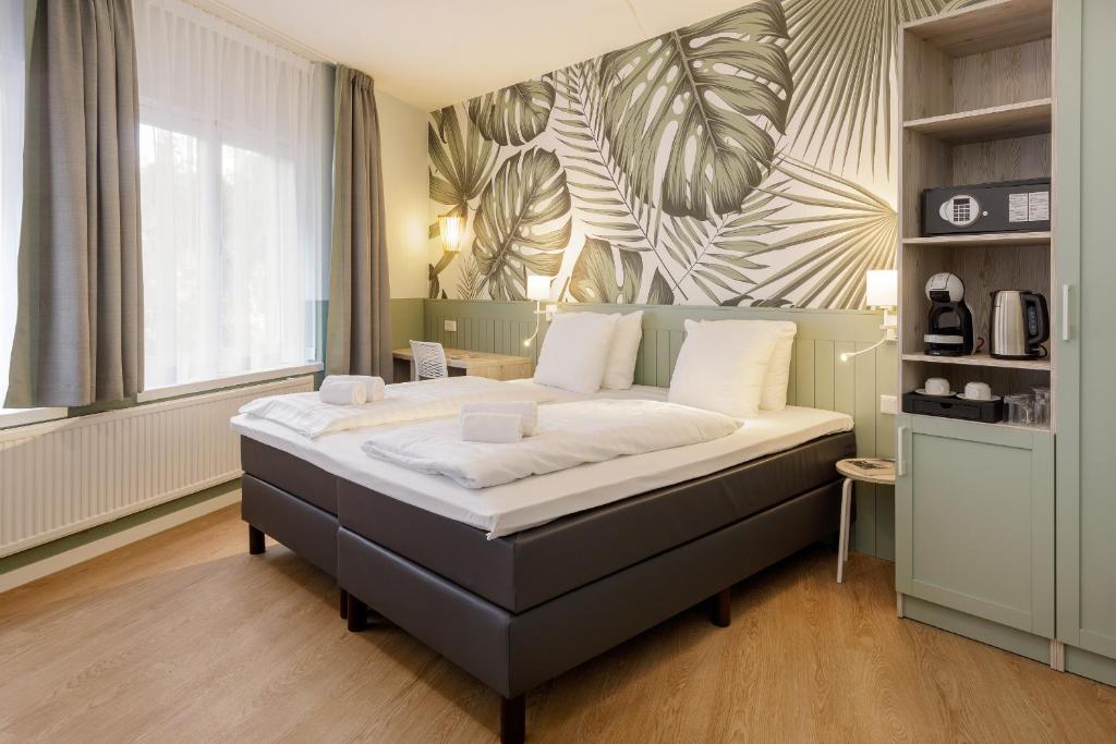 1 dormitorio con 1 cama grande en una habitación en Hotel Het Heijderbos by Center Parcs, en Heijen