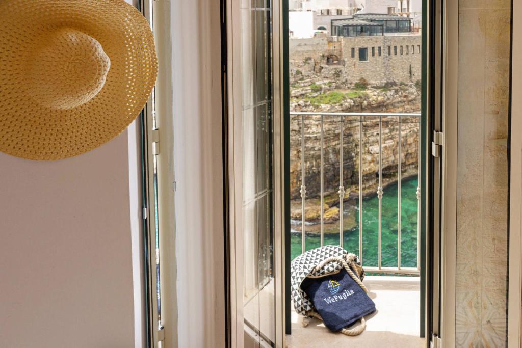 een kamer met een raam met uitzicht op de oceaan bij WePuglia - Sogno Blu in Polignano a Mare