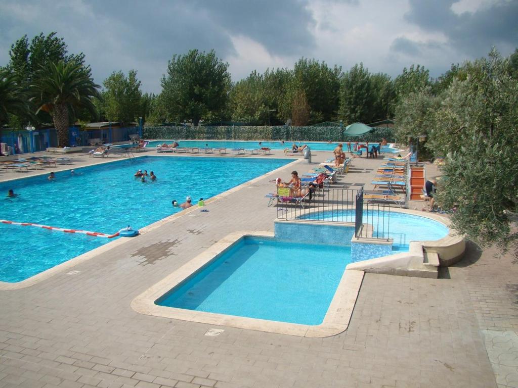 ein großer Pool mit Menschen im Wasser in der Unterkunft Camping Village Nice Garden in Ardea