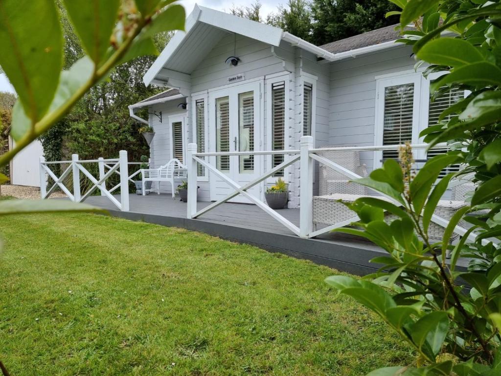 a white house with a porch and a yard at Willow House B&B in West Wittering