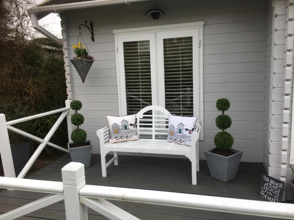 a white bench on the porch of a house at Willow House B&B in West Wittering