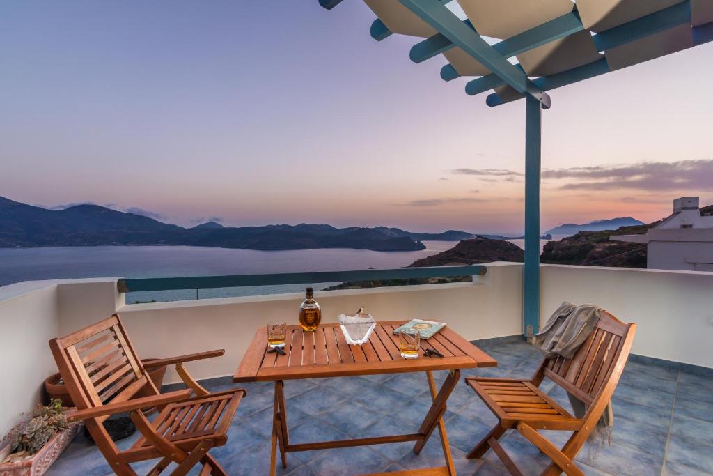 stół i krzesła na balkonie z widokiem na ocean w obiekcie Villa Blue Sky w mieście Trypiti