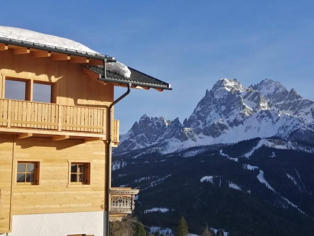 ein Gebäude mit einem schneebedeckten Berg im Hintergrund in der Unterkunft Panorama in Sexten