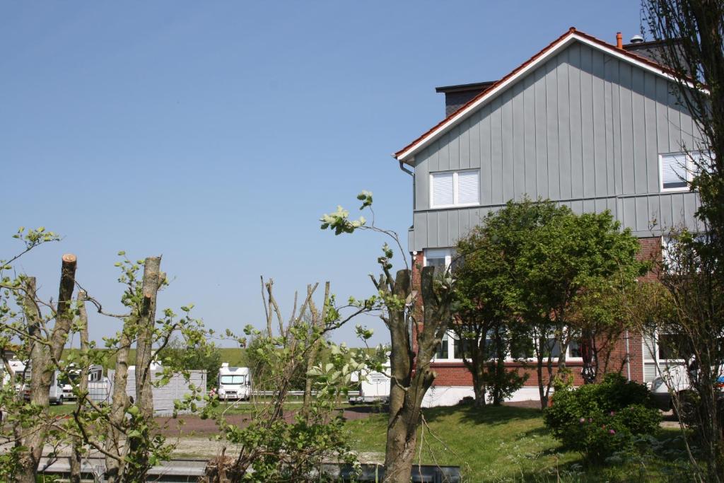 ein großes Gebäude mit Bäumen davor in der Unterkunft Gasthof Großer Krug in Norddeich