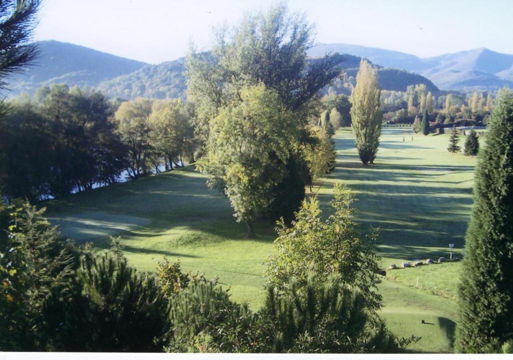 a view of a golf course with trees and mountains at Pyrénées Passions - Gîtes de Charmes &amp; Caractère in Estadens