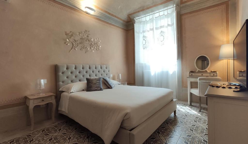 - une chambre avec un grand lit blanc et une fenêtre dans l'établissement Lo Strullo, à Pise