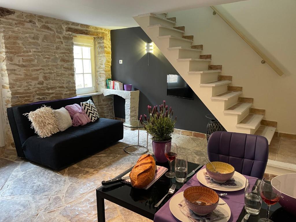 un salon avec un canapé et un escalier dans l'établissement Paradis de Provence, Wohnungen, à Le Pin