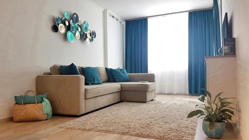 ein Wohnzimmer mit einem Sofa und blauen Kissen in der Unterkunft Nett Apartman in Siófok