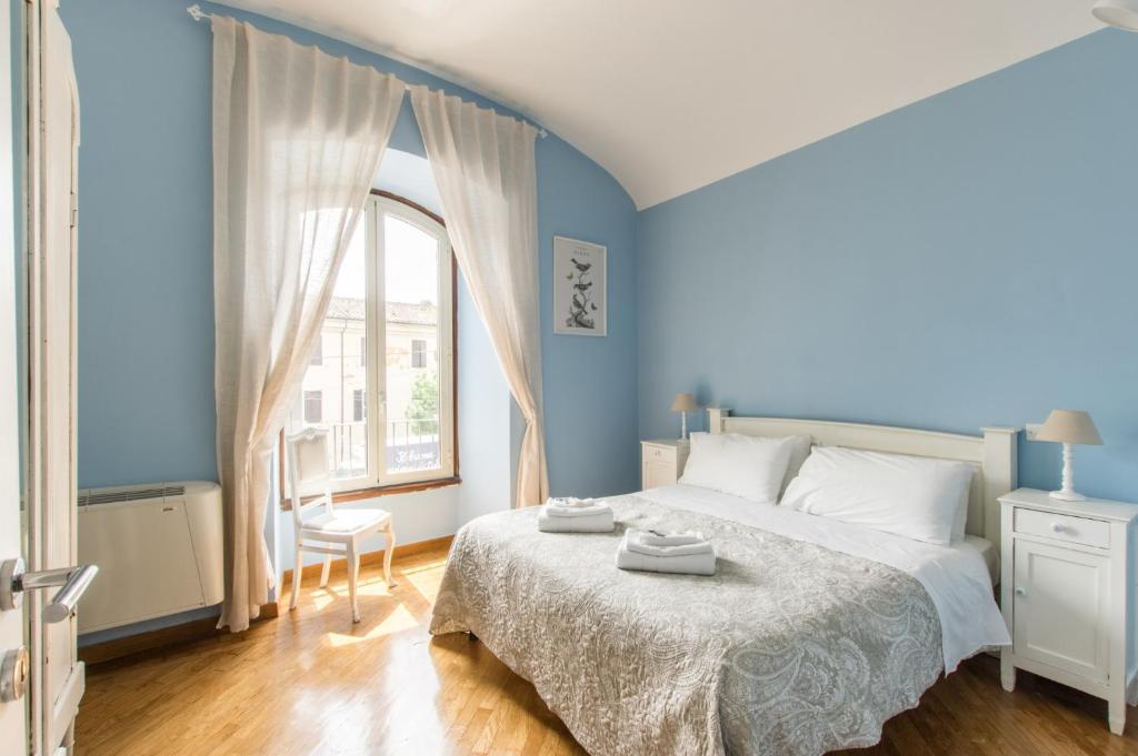 a blue bedroom with a bed and a window at Liberty Colosseo in Rome
