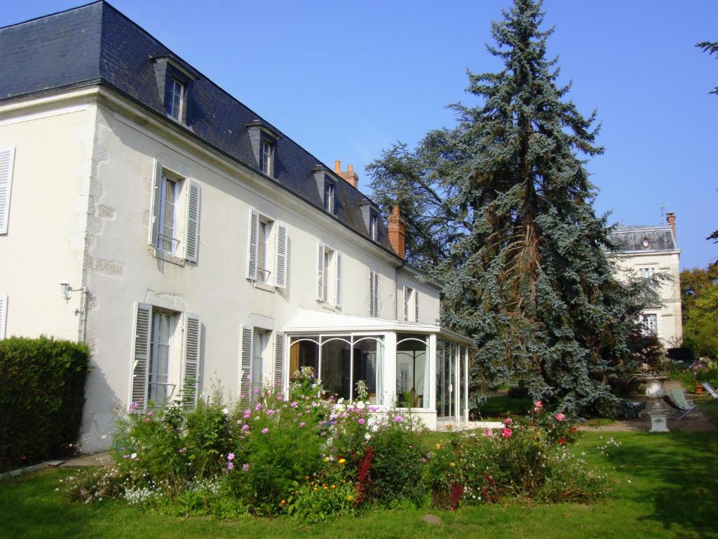 une maison blanche avec un arbre de Noël dans la cour dans l'établissement Appartements détente & nature - Domaine de La Thiau, à Briare