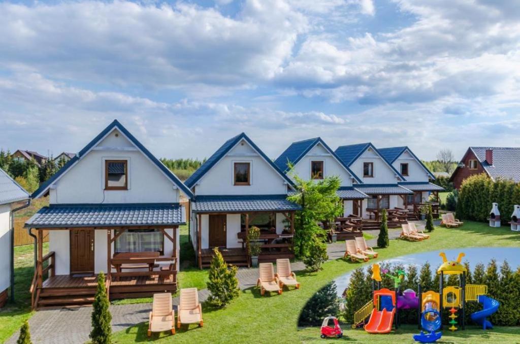 a house with a yard with chairs and a playground at Domki Plaża in Władysławowo