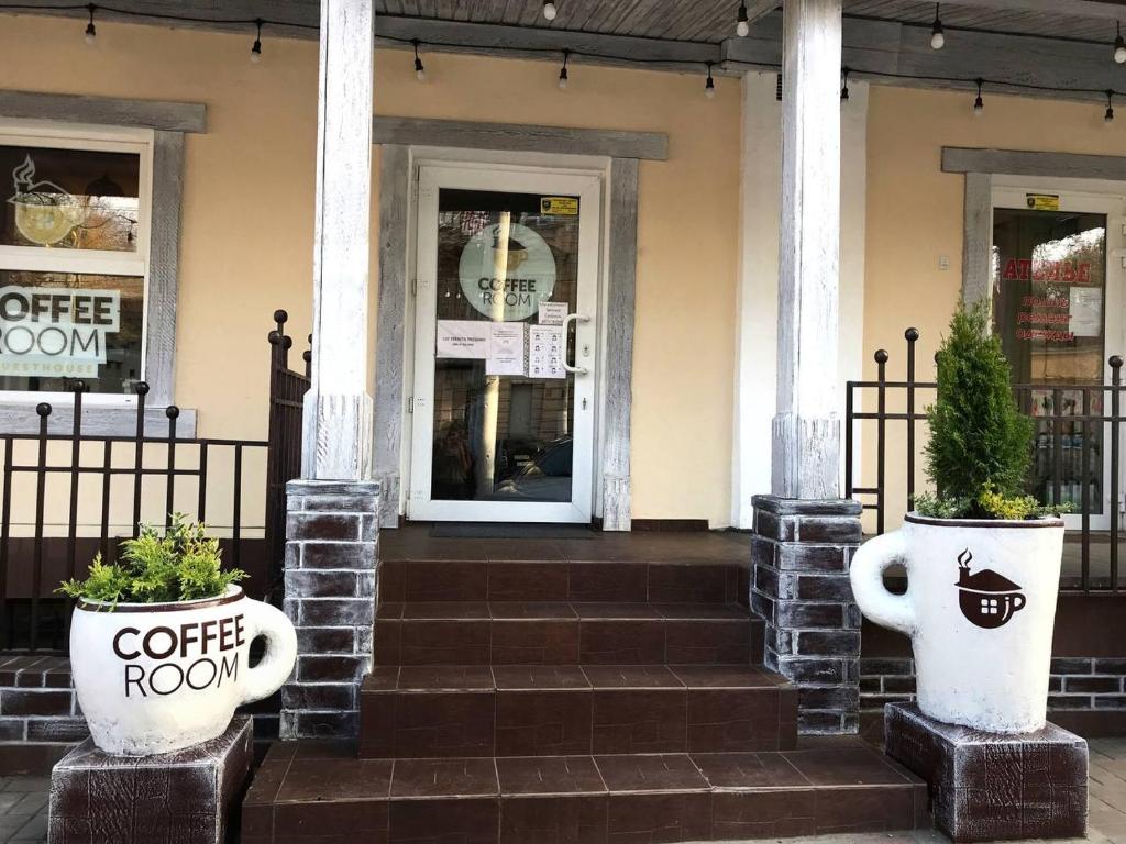 Coffee Room في أوديسا: غرفة قهوة مع اثنين من النباتات الفخارية أمام المبنى