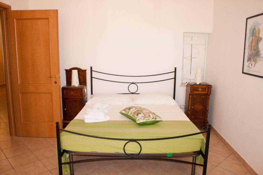 a bedroom with a bed with a green blanket on it at La casa di Matilde in Rodi Garganico