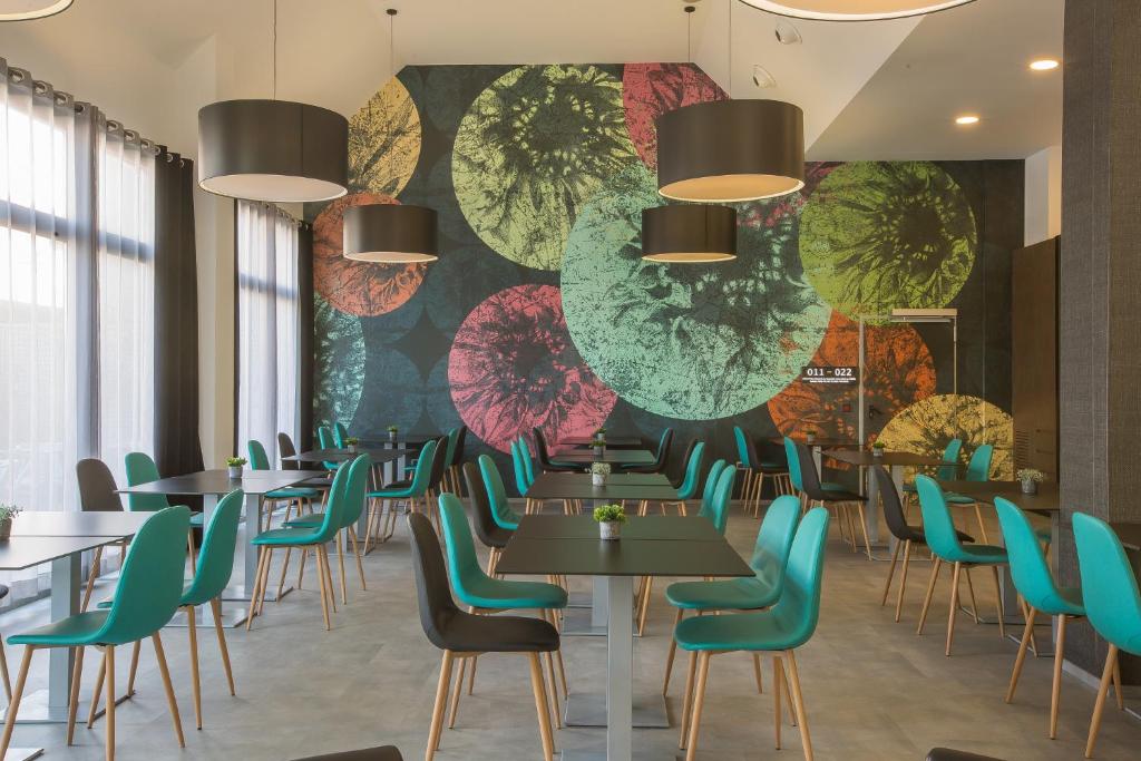 een restaurant met tafels en stoelen en een muur met parasols bij Hotel Venture Sant Cugat in Sant Cugat del Vallès