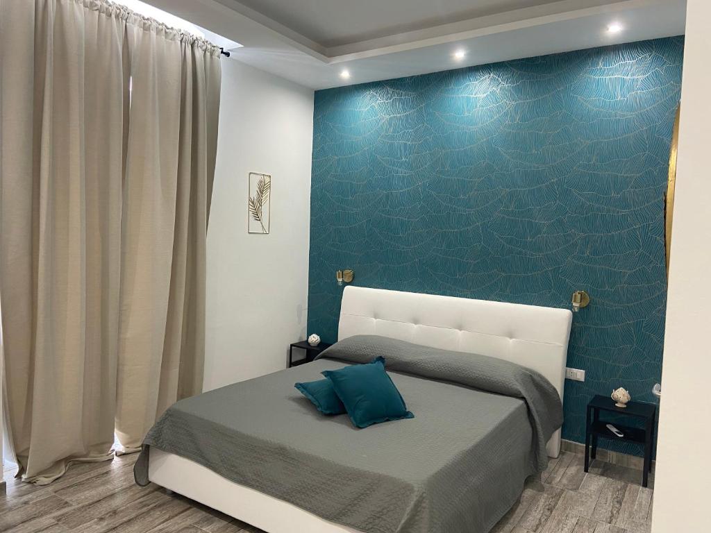 ein Schlafzimmer mit einem Bett und einer blauen Wand in der Unterkunft Room27 in Taranto