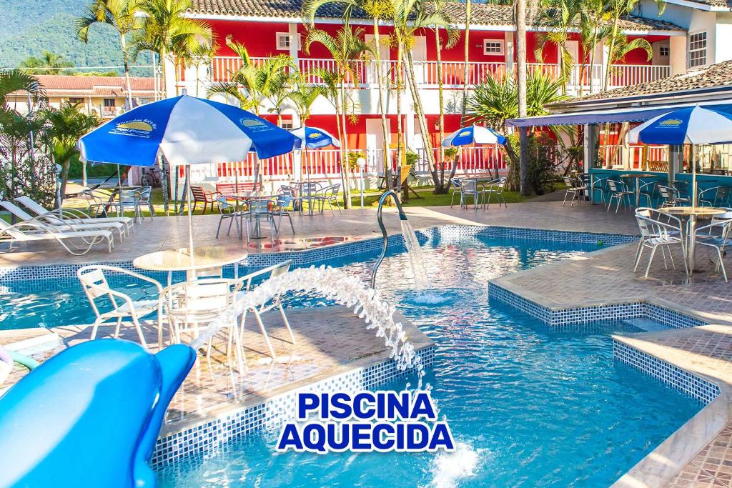 a pool with a water slide in a resort at Hotel Pousada Vivendas do Sol e Mar in Caraguatatuba