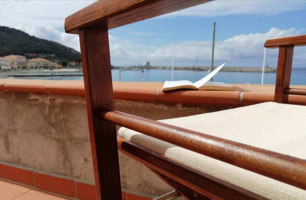 un libro en un balcón con vistas al agua en La casina di Alice, en Marciana Marina