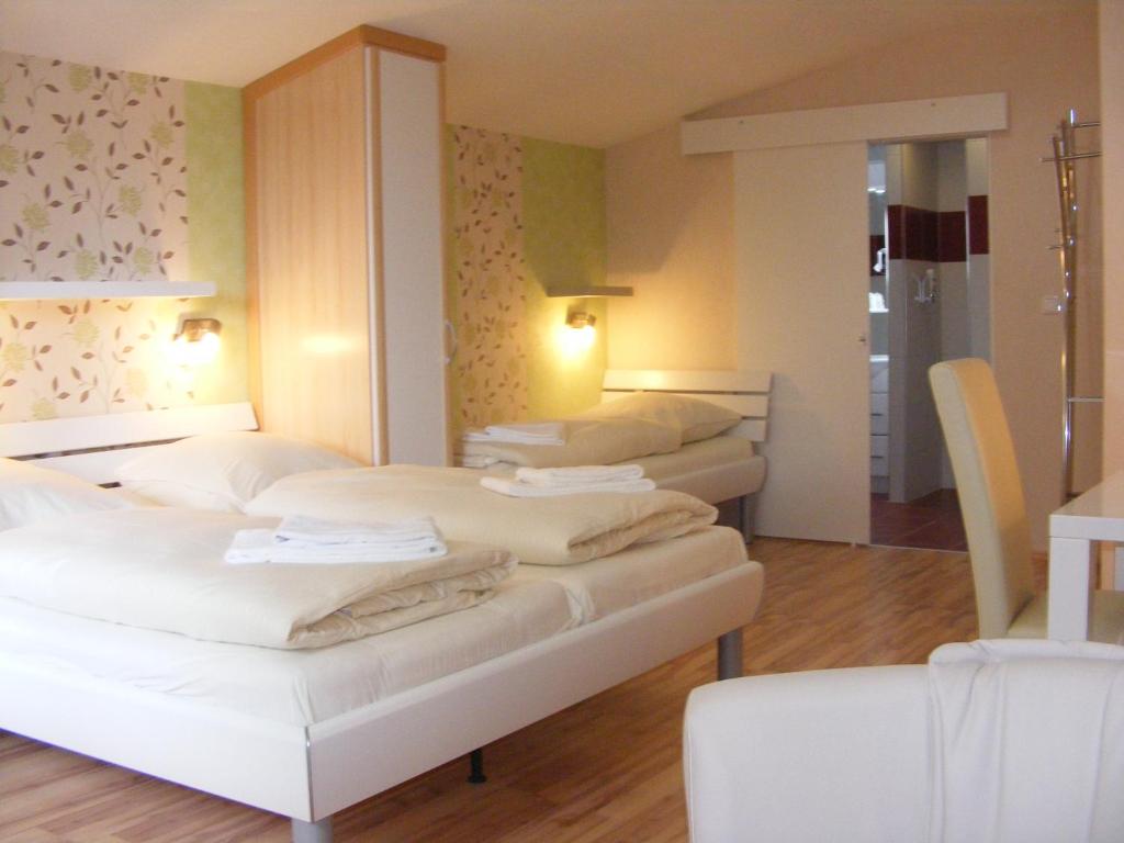 een hotelkamer met 3 bedden en een spiegel bij Landgasthof Tarp in Tarp