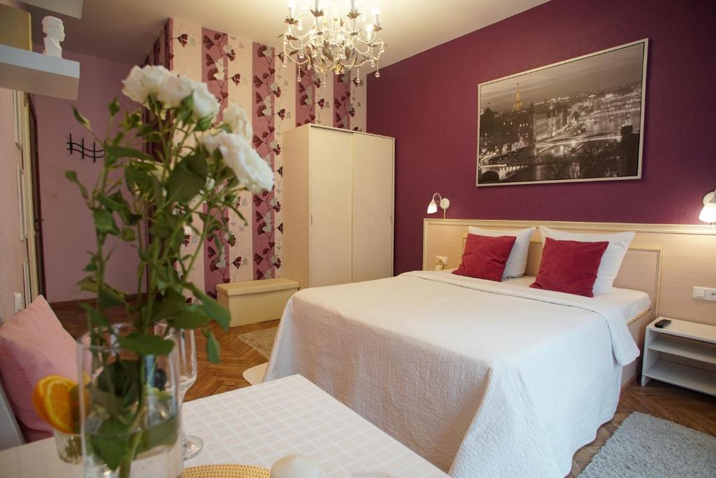 a bedroom with two beds and a vase of flowers at Pro Счастье in Saint Petersburg