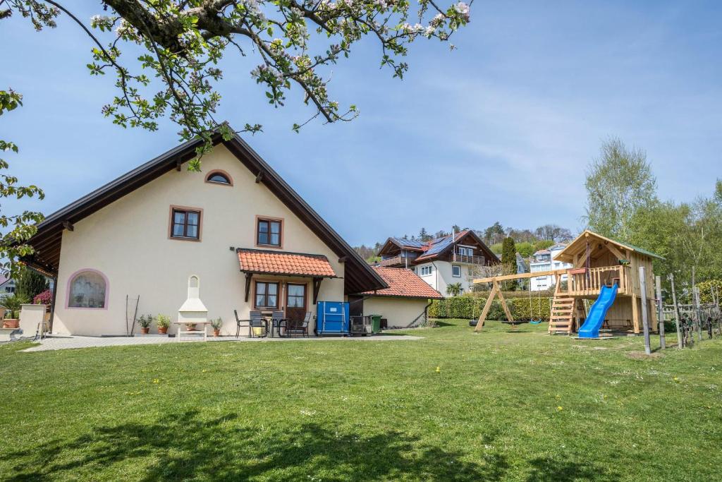 een huis met een speeltuin in de tuin bij Ferienwohnung Heimpel in Kressbronn am Bodensee