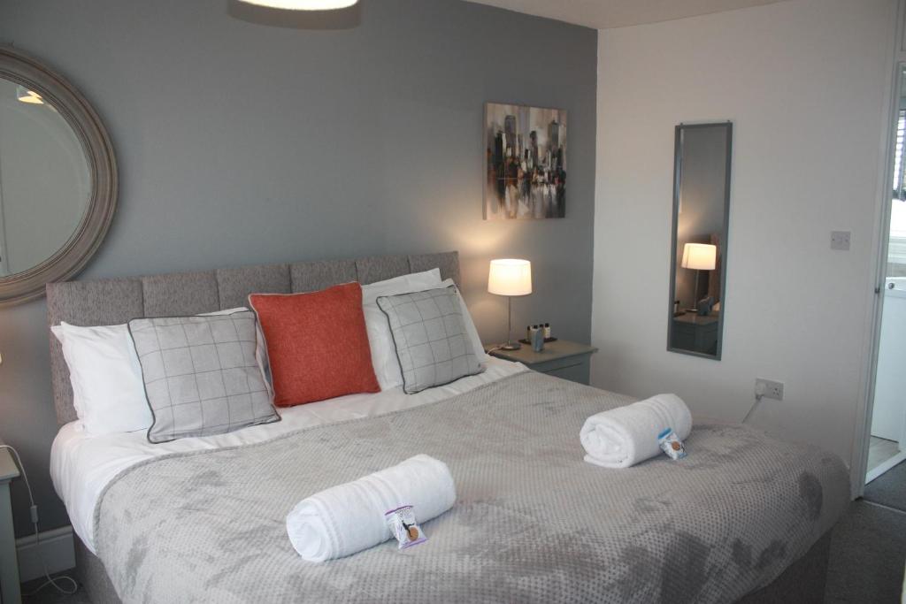 a bedroom with a large bed with two pillows on it at Berwicks House - NEC & Airport - Stylish 3-bed house with garden in Birmingham