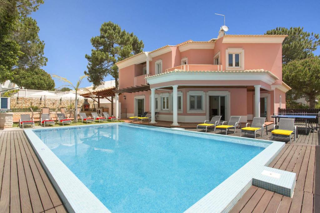 a villa with a swimming pool in front of a house at Villa Falesia Mar by Villa Plus in Olhos de Água