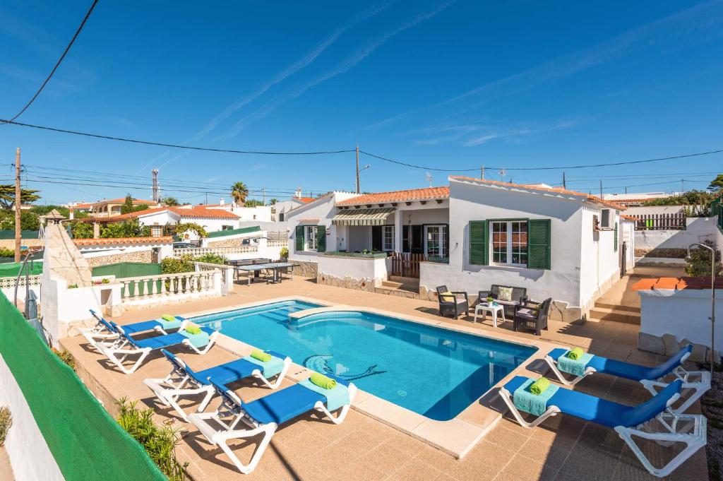a villa with a swimming pool and patio furniture at Villa Paloma by Villa Plus in Cala'n Porter