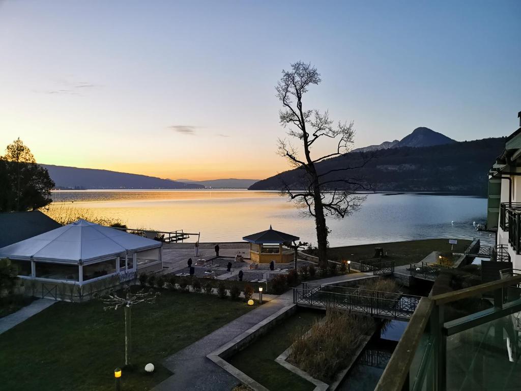 Cette tente offre une vue sur le lac au coucher du soleil. dans l'établissement Lac Annecy plage privée, Duplex Baie des voiles, à Duingt