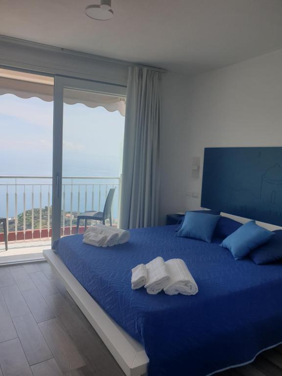 a bedroom with a blue bed with towels on it at Case Vacanze da Birba in Ravello