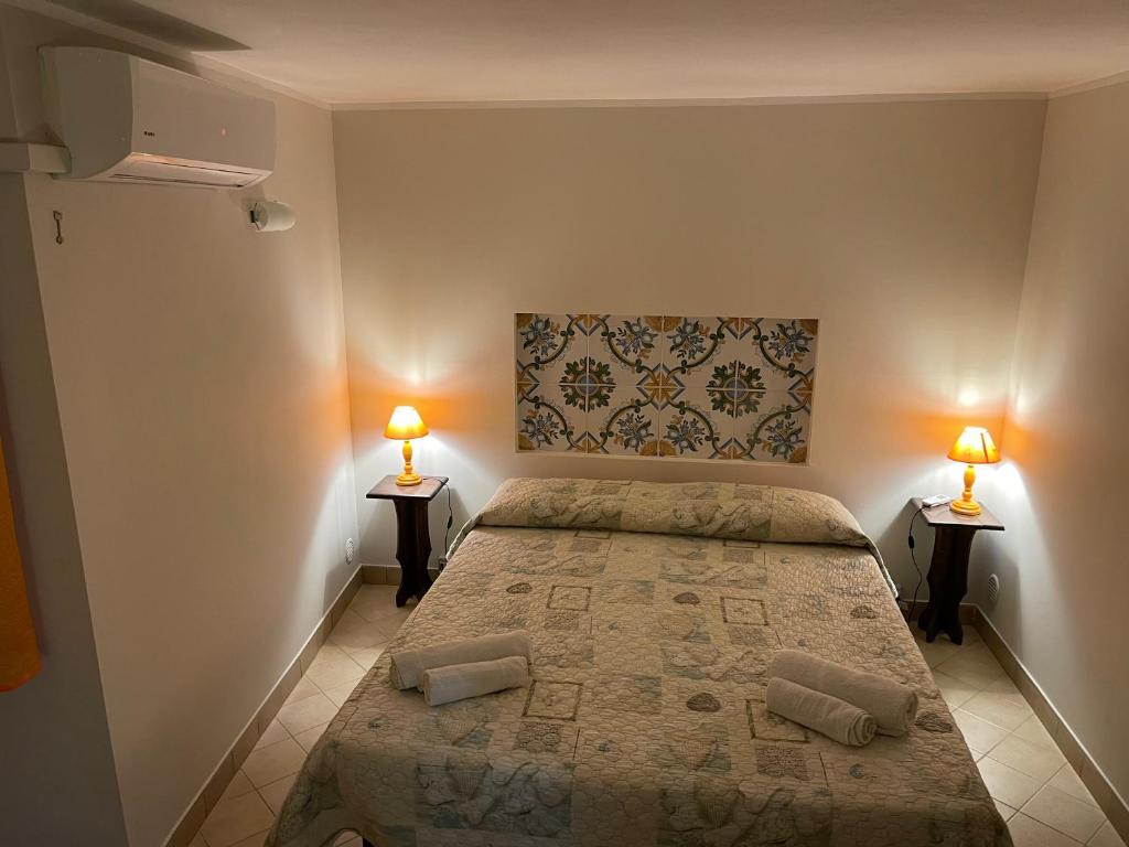 ein Schlafzimmer mit einem Bett und zwei Lampen an zwei Tischen in der Unterkunft Normanni Central House in Palermo