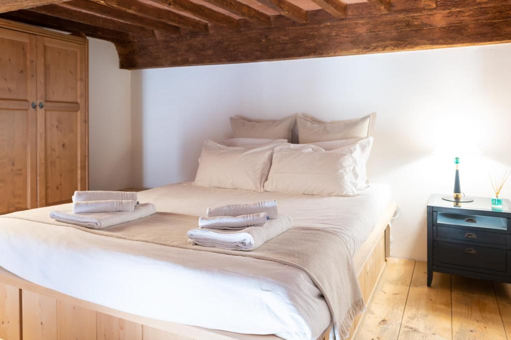 1 dormitorio con 1 cama blanca grande y toallas. en LEI Luxury Suite en San Miniato