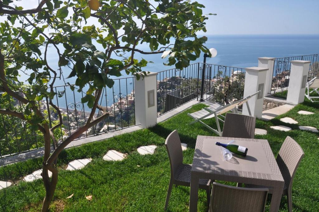 un tavolo e sedie su un balcone con vista di Casa Roberta a Positano
