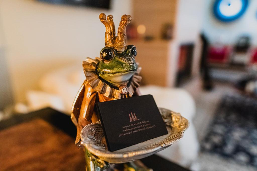 a frog with a crown on its head on a plate at Noelle Mountain Suites in Kalavrita