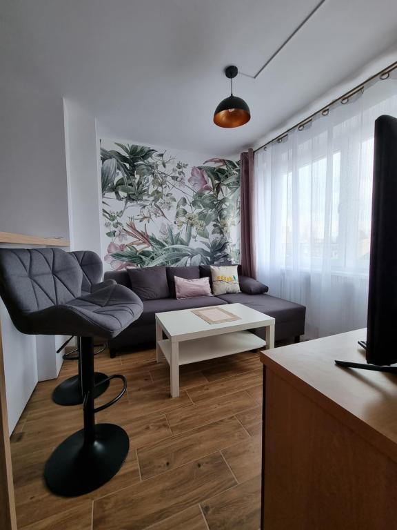 ein Wohnzimmer mit einem Sofa und einem Tisch in der Unterkunft Kawalerka blisko jeziora in Olecko