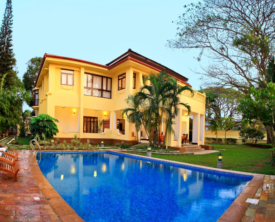 a house with a swimming pool in front of a house at Amritara The Poovath Beachfront Heritage, Fort Kochi in Cochin