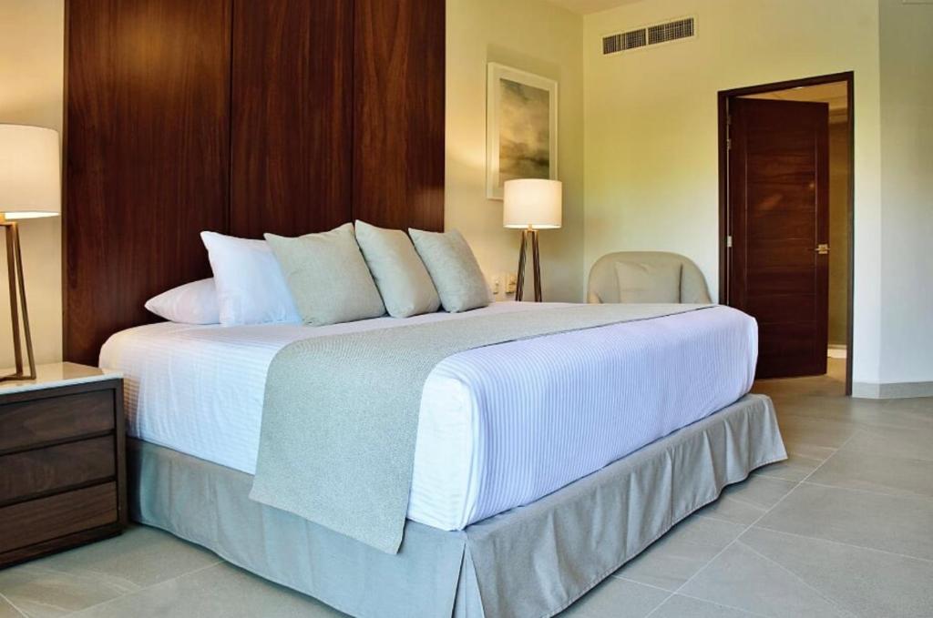 una camera da letto con un grande letto con lenzuola e cuscini bianchi di 2 Bed 2Bth, Playa Royale 2507, Free WIFI a Nuevo Vallarta