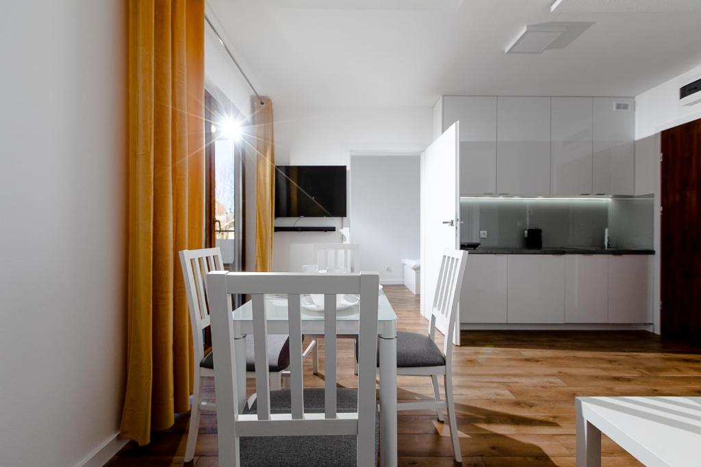 eine Küche und ein Esszimmer mit einem Tisch und Stühlen in der Unterkunft Apartament 'Niechorze' in Niechorze
