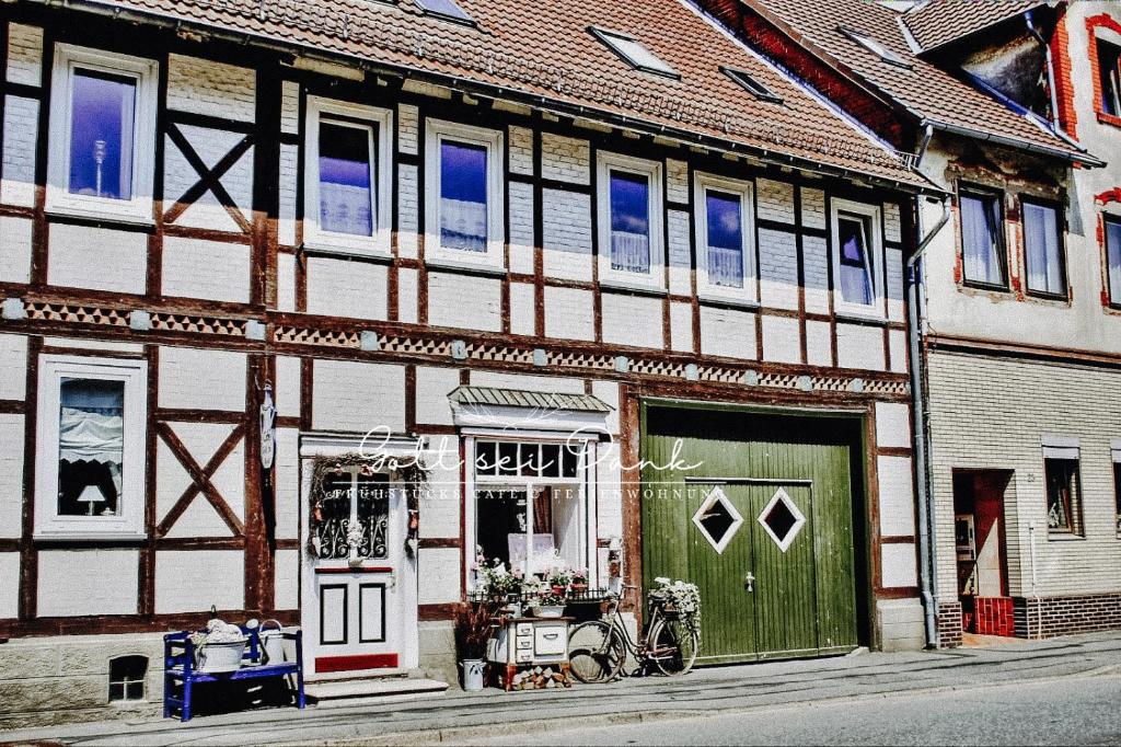 a building with a green door and a bike parked outside at Ferienwohnung "Gott sei Dank" in Herzberg am Harz