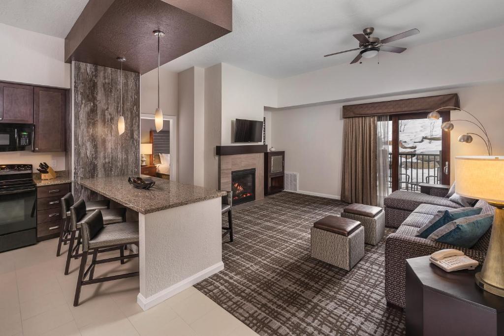 a living room with a kitchen and a living room with a fireplace at Club Wyndham Park City in Park City