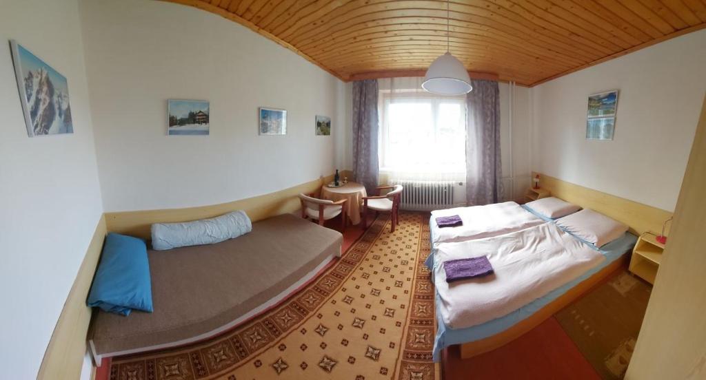 a small room with two beds and a window at Pension MAAN in Tatranska Strba