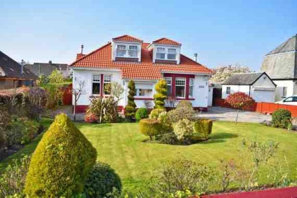 a house with a green yard with bushes at 2 bedroom appartment loch lomond in Balloch