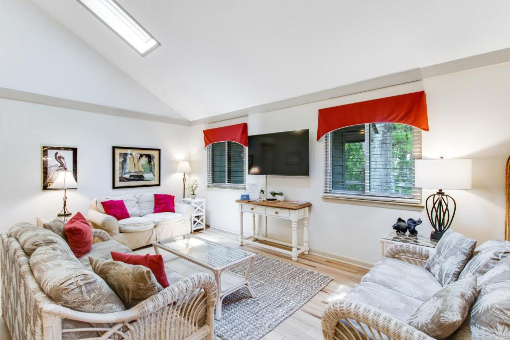 ein Wohnzimmer mit zwei Sofas und einem Fernseher in der Unterkunft 460 Oceanwoods Cottage in Kiawah Island