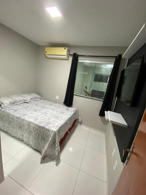 a small bedroom with a bed and a mirror at Ap no campo dos velhos com ar in Sobral
