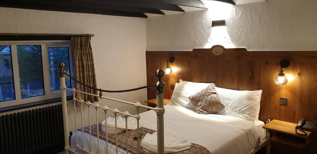 a bedroom with a bed with a wooden head board at The Blue Boar in Alcester